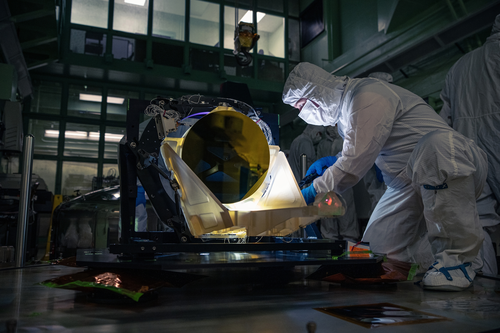 A technician inspects a prototype LISA telescope.